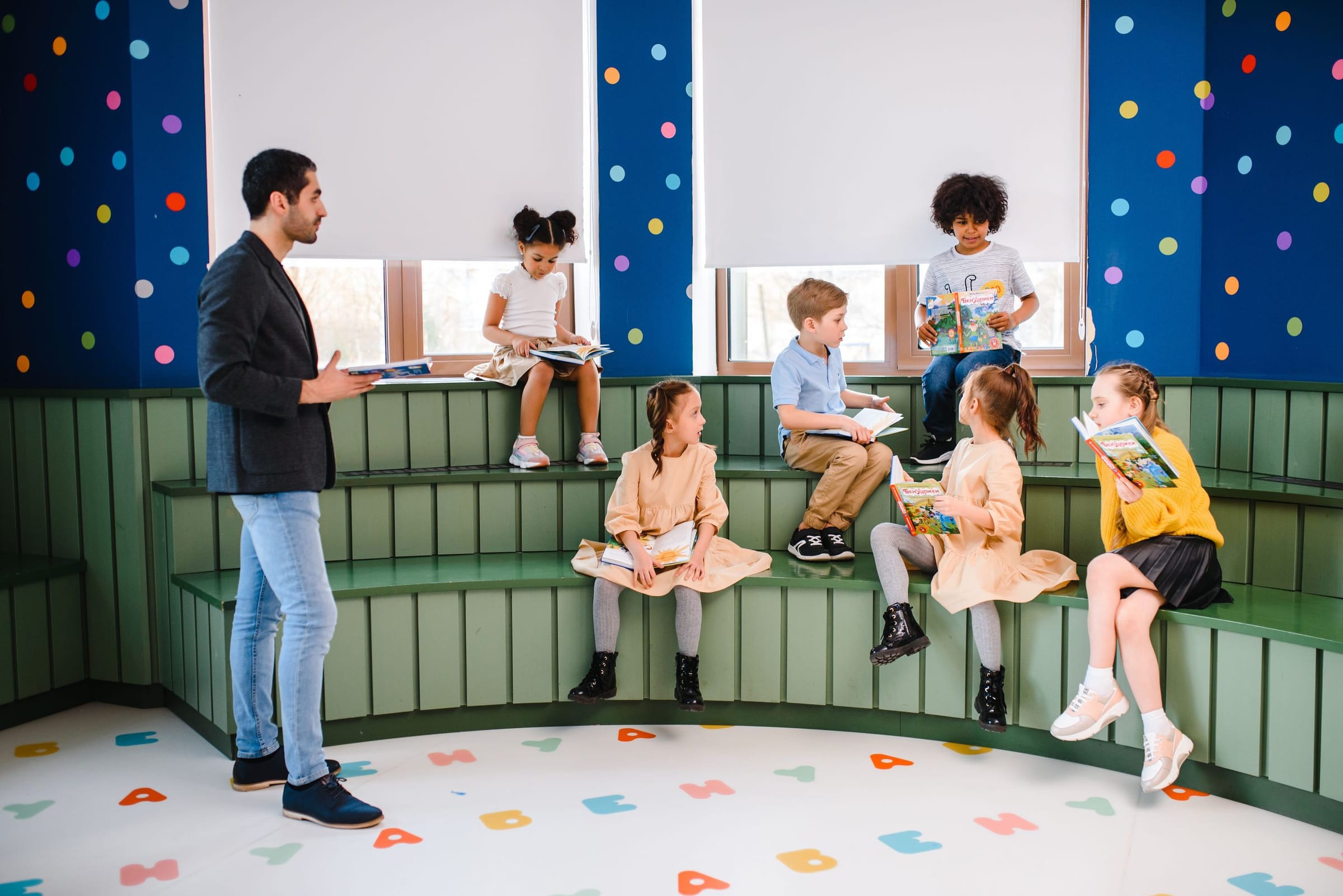Children reading together on the tiered bench of a primary learning room