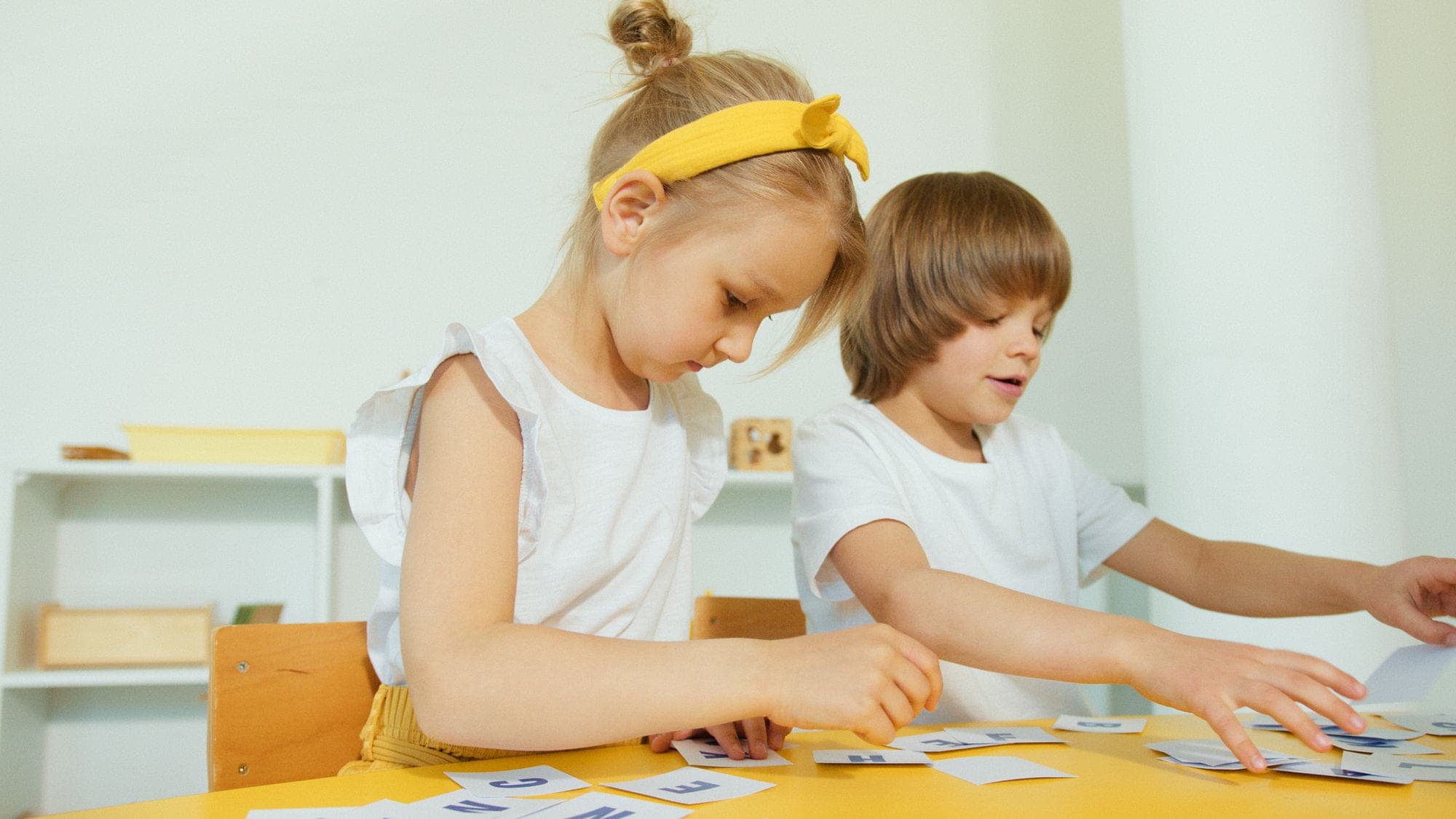 Two young children working through a matching activity side by side